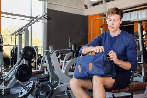 Young man with sport bag in gym
