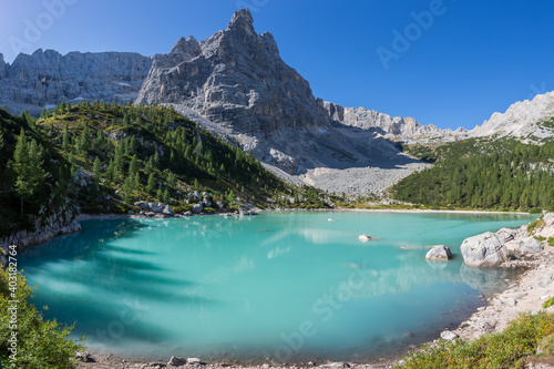 peak of Dito di Dio mountain and green water of lake Sorapis