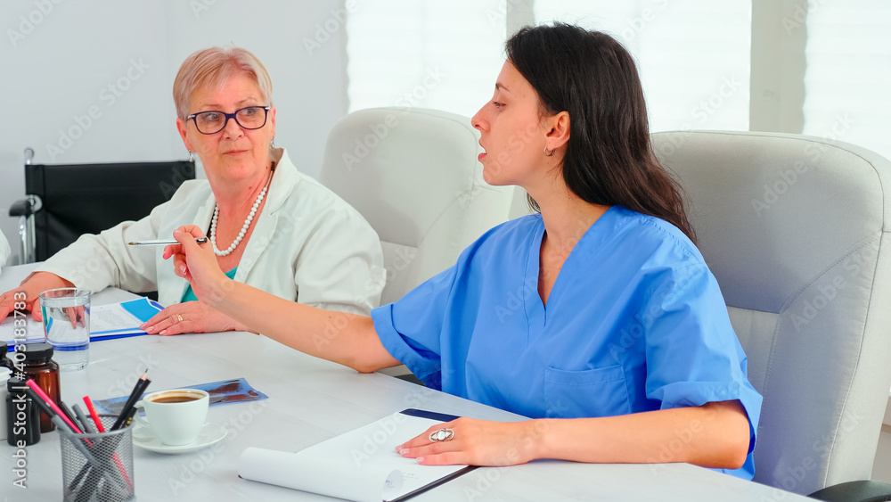 Obraz premium Close up of medical nurse taking notes on clipboard during healtchare meeting with coworkers in hospital boardroom. Clinic expert therapist talking with colleagues about disease, medicine professional