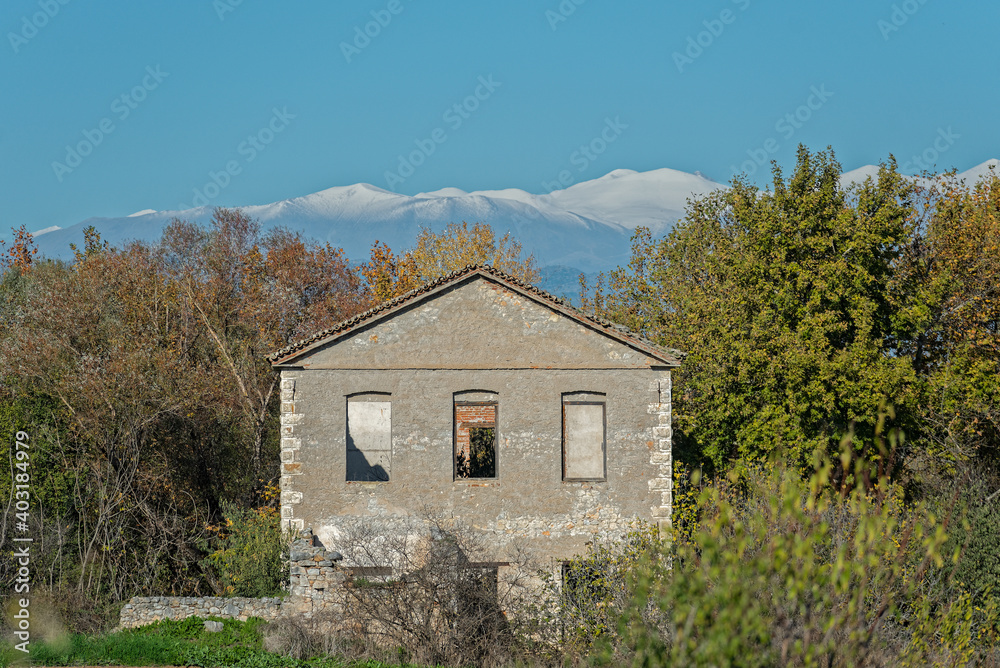 Old water mill, made of stones, in the background snow covered summits of mountain Olympus. Old water mill, made of stones, in the background snow covered summits of mountain Olympus.