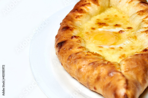 Ajarian traditional flatbread khachapuri or hachapuri with cheese, egg and butter on a plate