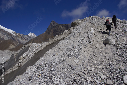 Hikers crossing Ngozumpa glacier (longest Himalayan glacier). Stone covered glacier.