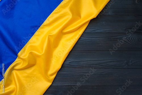 National flag of Ukraine on dark wooden background