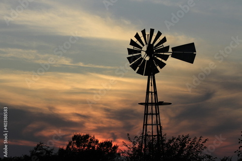 windmill at sunset with clouds north of Hutchinson Kansas USA out in the country.