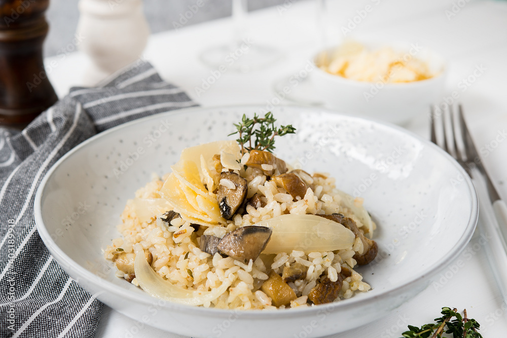 Risotto with porcini mushrooms and parmesan on a light background