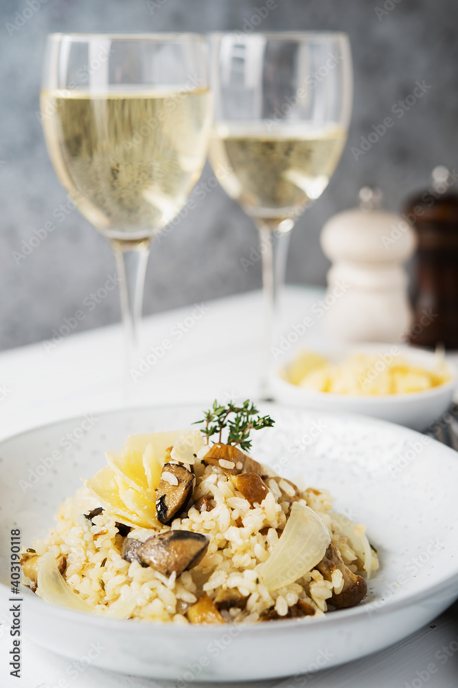 Risotto with porcini mushrooms and parmesan on a light background, selective focus Risotto with porcini mushrooms and parmesan on a light background, selective focus