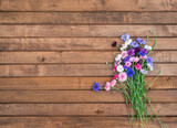 Colorful bouquet of summer garden flowers. Cornflowers on brown wooden table. Vintage floral background. Copy space
