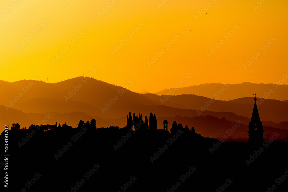 Sunset with hills and mountains in silhouettes Sunset with hills and mountains in silhouettes