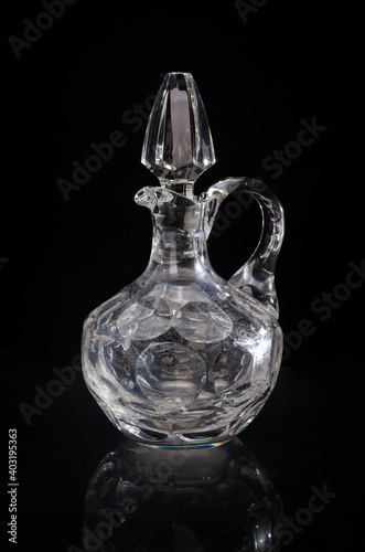 Lead cut crystal decanter isolated on black background.