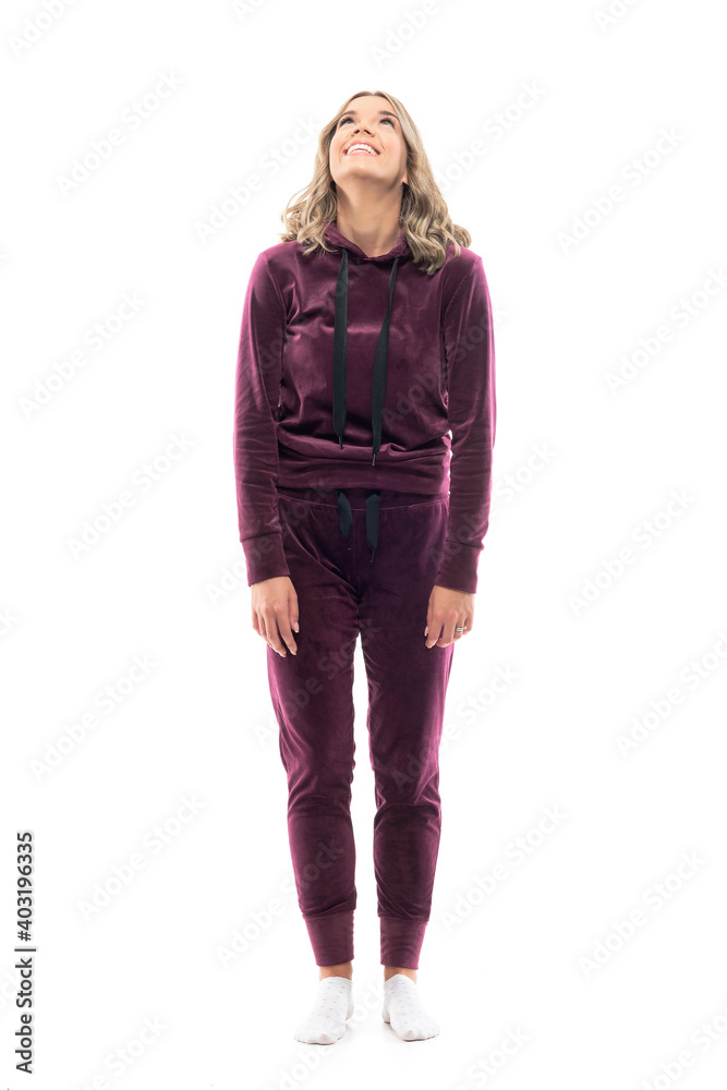 Happy relaxed young leisure wear woman smiling and looking up watching above at attention. Full body length isolated on white background. Happy relaxed young leisure wear woman smiling and looking up watching above at attention. Full body length isolated on white background.