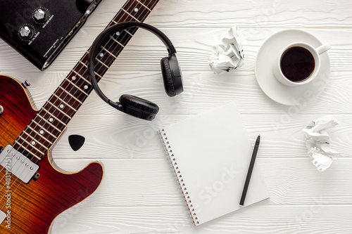 Desk of musician for songwriter work set with headphones and guitar