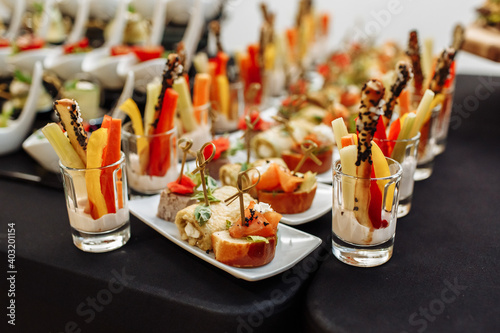 Festive Buffet. An assortment of cold cuts and canapes on wooden skewers. Cocktail reception at the party. catering with meats, fruits, cheeses and sandwiches.