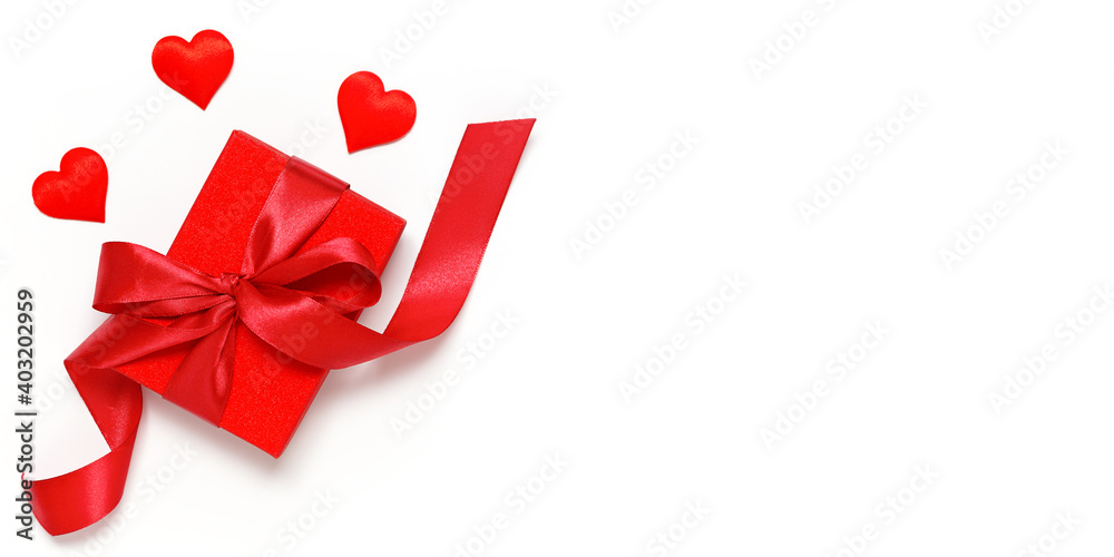 Red gift box tied with a ribbon with decorative hearts on a white background Red gift box tied with a ribbon with decorative hearts on a white background