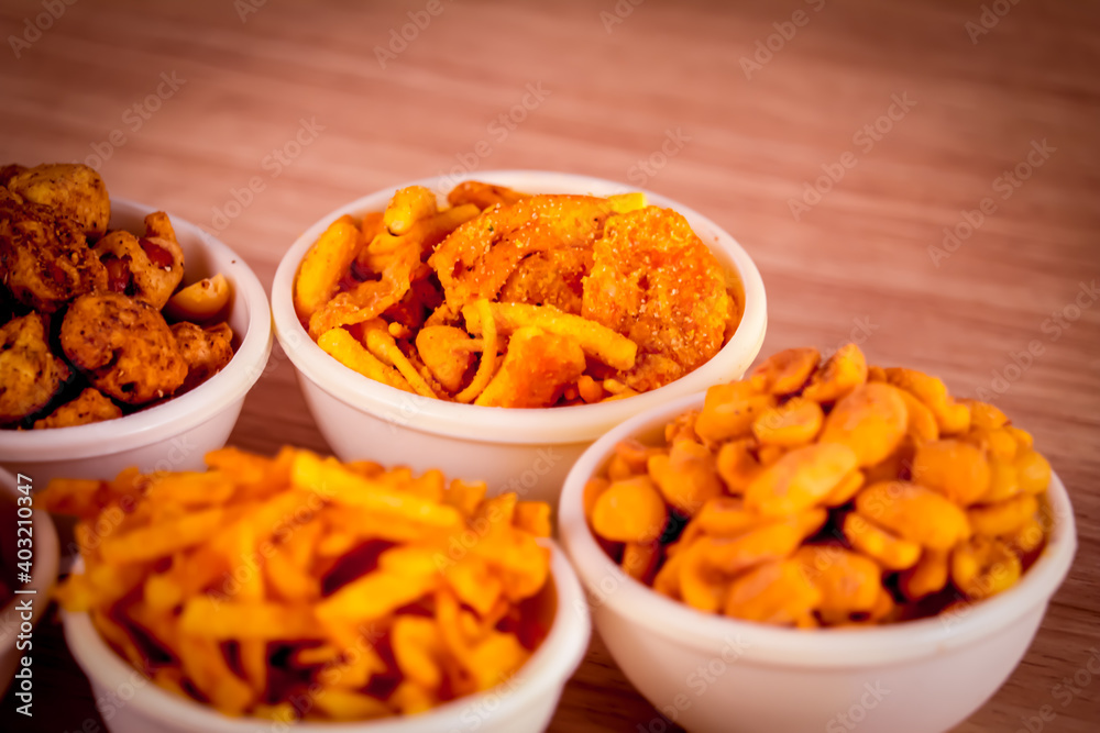 indian namkeen on wooden table,Indian Namkeen or snacks in white bowl on wooden background, close up of indian Namkeen snacks beautiful footage,Sev murmura,chanadal,shing bhujia,mix chavana indian namkeen on wooden table,Indian Namkeen or snacks in white bowl on wooden background, close up of indian Namkeen snacks beautiful footage,Sev murmura,chanadal,shing bhujia,mix chavana