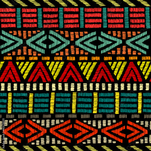 Embroidered ethnic seamless pattern. Aztec and tribal motifs. Striped ornament hand drawn. Print in the bohemian style. Vector illustration.