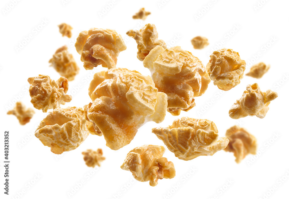 Caramel-flavored popcorn levitates on a white background Caramel-flavored popcorn levitates on a white background