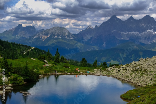 colorful hikers on the shore from a mountain lake in the summer