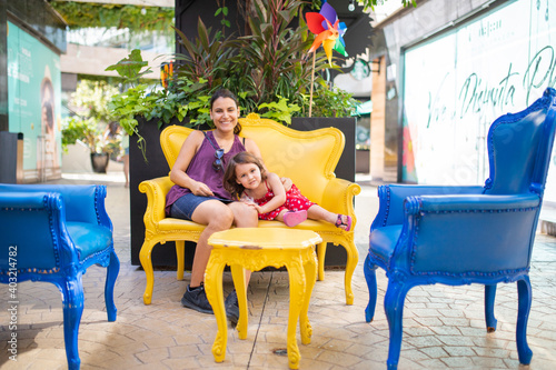 Wallpaper Mural Happy mother and daughter sitting on yellow armchair in an alley Torontodigital.ca
