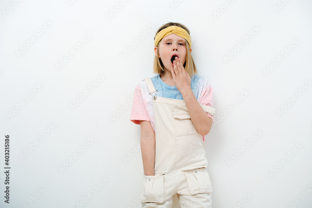 Young teenager girl blonde yawns, covering her mouth with her hand. Young teenager girl blonde yawns, covering her mouth with her hand.