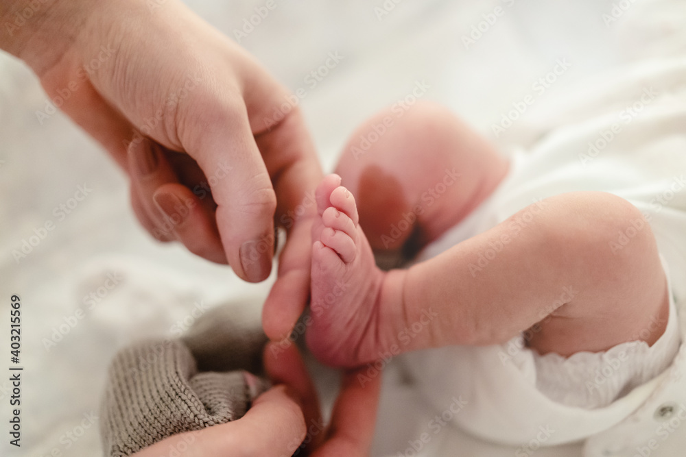 Tiny newborn feet and mother hands, closeup. Tiny newborn feet and mother hands, closeup.