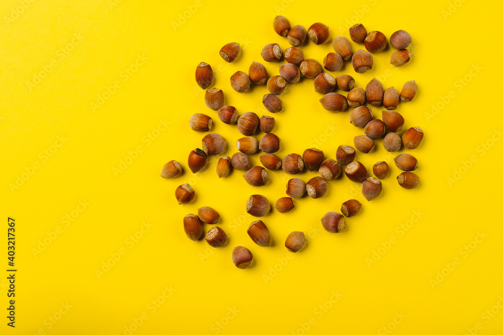 Hazelnuts on a illuminating background are scattered in the shape of a heart. St Valentines Day concept. Empty space. Hazelnuts on a illuminating background are scattered in the shape of a heart. St Valentines Day concept. Empty space.