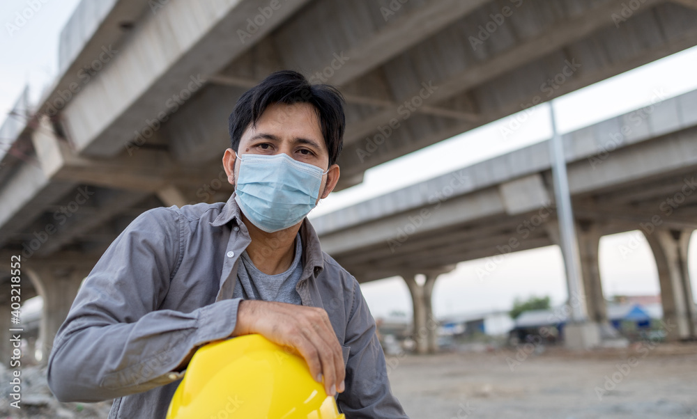 Construction worker asian man wearing a medical mask to prevent Covid-19 in construction site Construction worker asian man wearing a medical mask to prevent Covid-19 in construction site