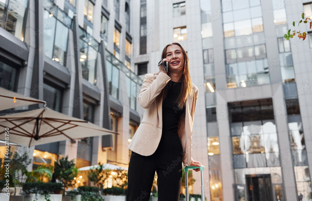 Town style clothes. Beautiful young european woman is outdoors in the city at daytime Town style clothes. Beautiful young european woman is outdoors in the city at daytime