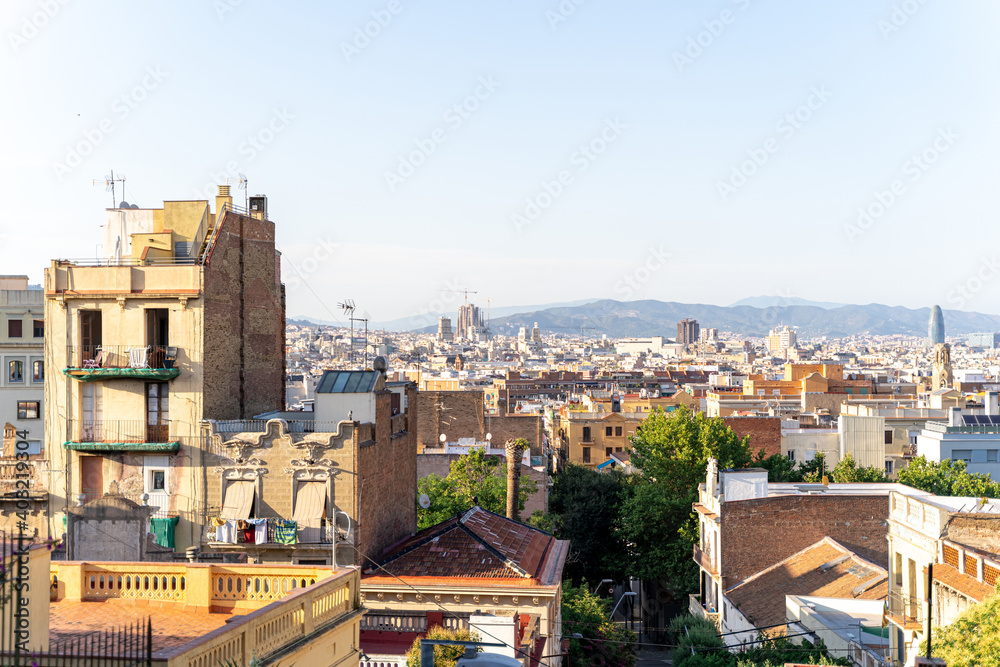 Aerial view of the Barcelona skyline with many buildings on a sunny summer day