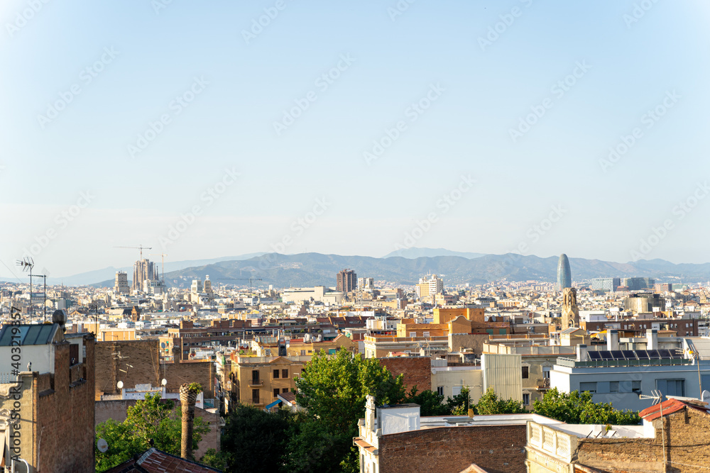 Aerial view of the Barcelona skyline with many buildings on a sunny summer day
