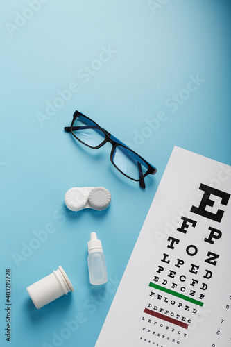 Ophthalmic Accessories Glasses and lenses with an Eye Test Chart for vision correction on a blue background