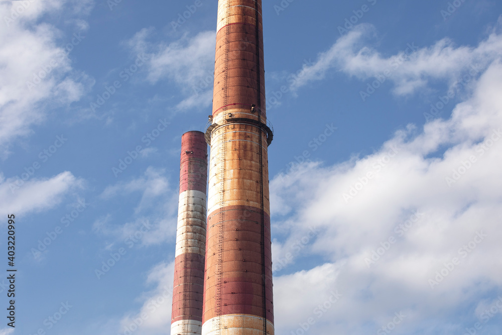 Close-up of old brick industrial chimneys by coal mine in Katowice. Abstract industrial background. Global warming, CO2 emission, coal energy issues. Close-up of old brick industrial chimneys by coal mine in Katowice. Abstract industrial background. Global warming, CO2 emission, coal energy issues.