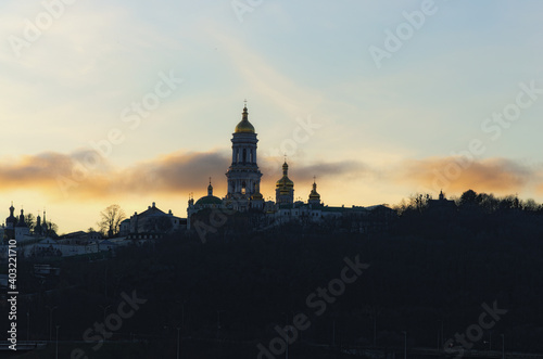 Picturesque winter landscape view of famous Kyiv's hills against cloudy sky during sunset. Scenic landscape of ancient Kyiv Pechersk Lavra. It is a historic Orthodox Christian monastery. Kyiv, Ukraine