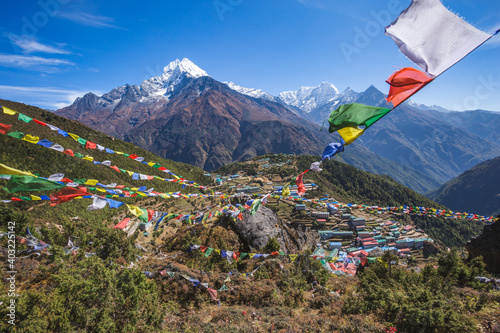 Prayer flags with Buddhist mantras in the background of Namche Bazar village. Nepal photo