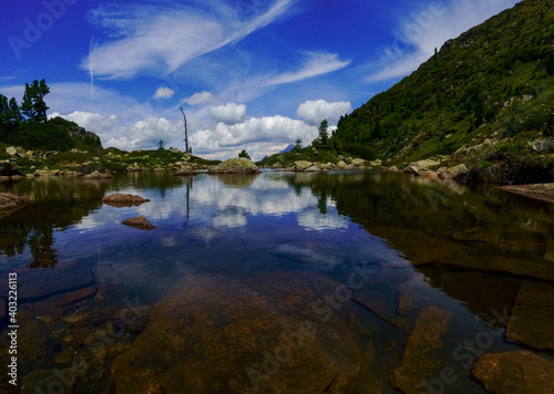 mountain lake with reflection from the sky while hiking panorama