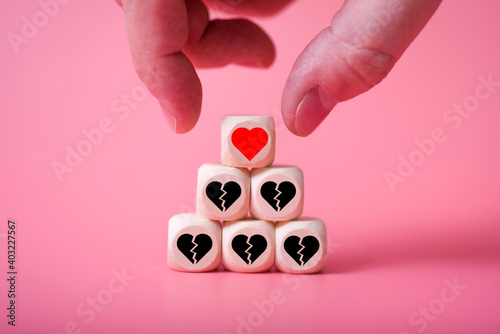 Love Valentine's Day conceptman hand takes the heart, with a pyramid of other broken hearts. photo