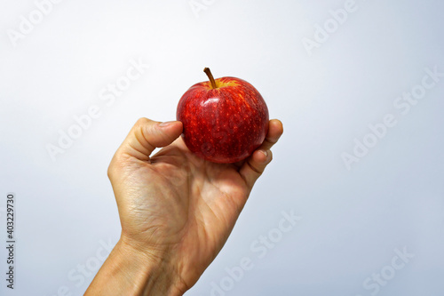 Red apple on hand in a bright background