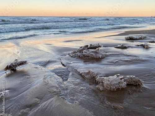 Winter sunset at Gillson Beach along Lake Michigan's Illinois shore. Waves left carvings on the beach which iced over from the frigid air.