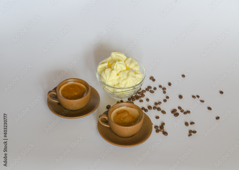 A cup of coffee, a delicate meringue dessert and coffee beans on a light background