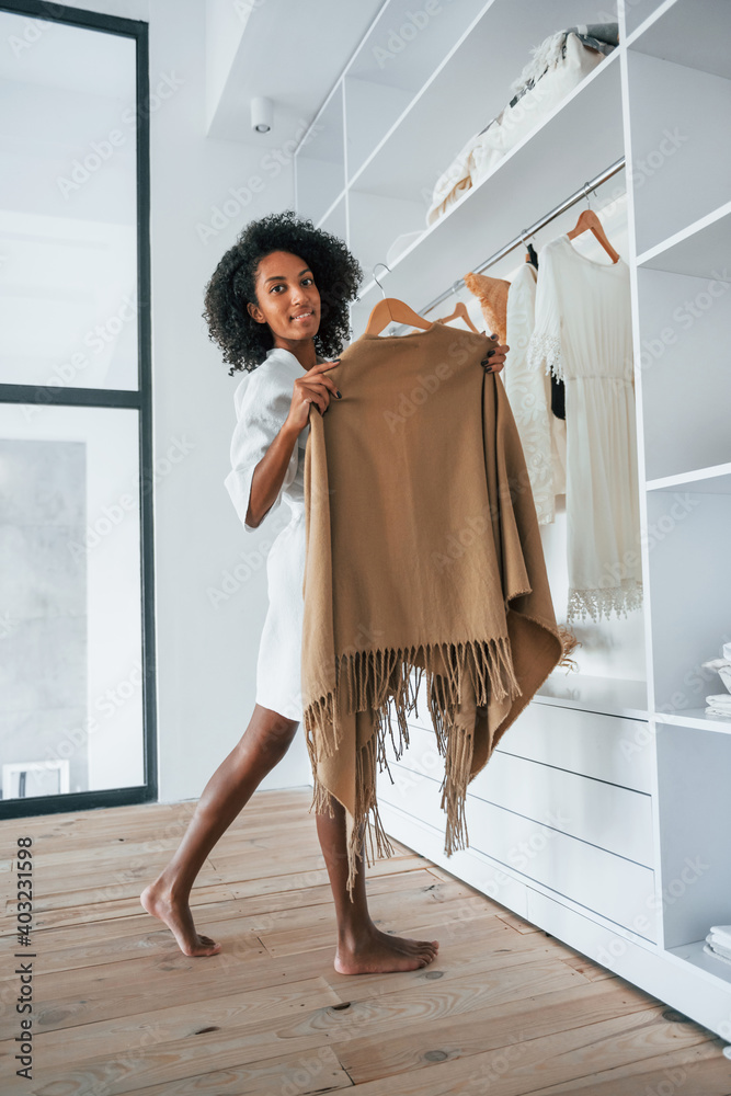 With different clothes. Young african american woman with curly hair indoors at home With different clothes. Young african american woman with curly hair indoors at home