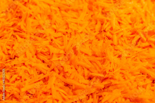 Orange textured surface of freshly grated carrots for a variety of healthy dishes