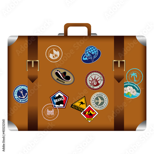 Valise vintage de face, décorée de divers autocollants, souvenirs de voyages touristiques.