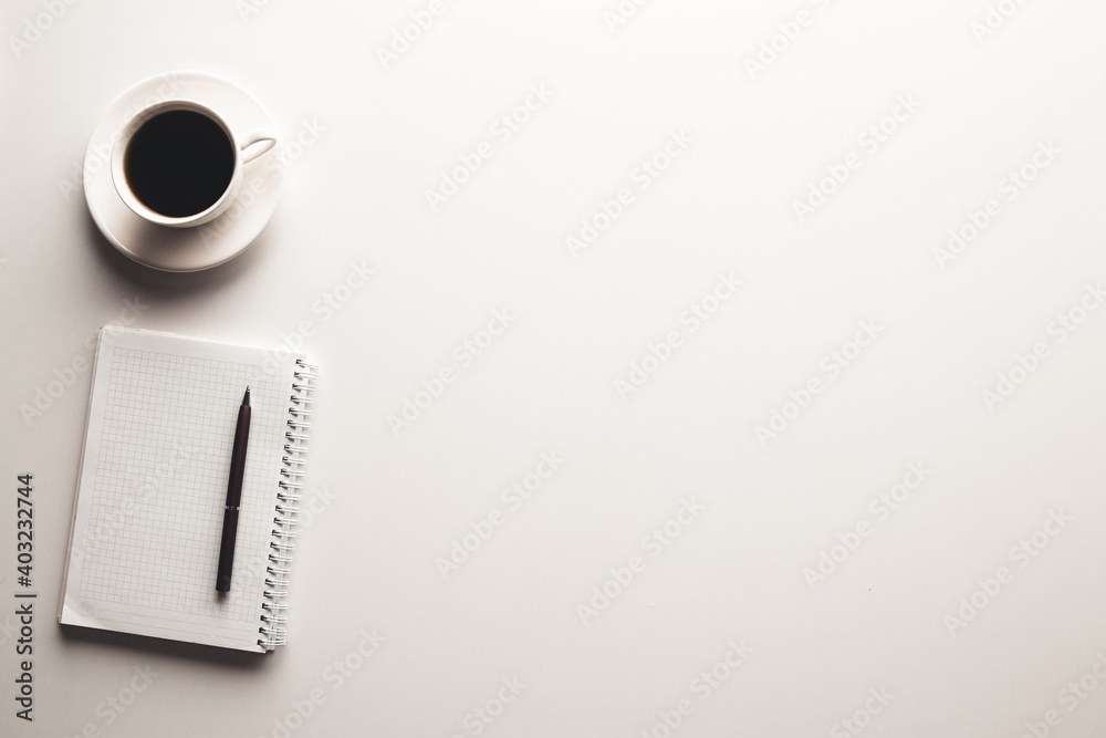 Office desk table with supplies, coffee cup and flower. Top view
