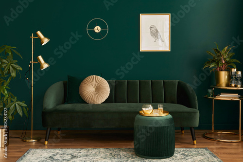 Luxury living room in house with modern interior design, green velvet sofa, coffee table, pouf, gold decoration, plant, lamp, carpet, mock up poster frame and elegant accessories. Template.