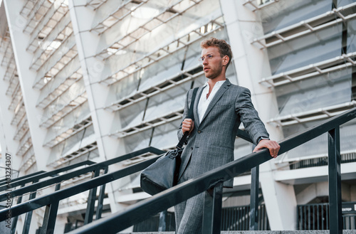 Wallpaper Mural Urban beauty. Young businessman in grey formal wear is outdoors in the city Torontodigital.ca