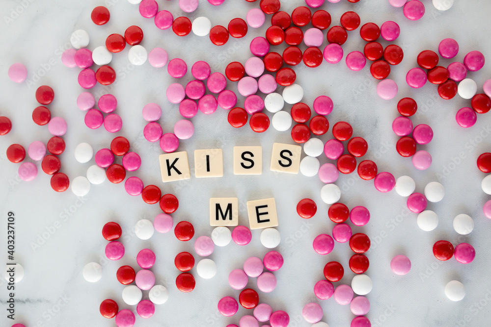 the words kiss me written in scrabble tiles on a marble kitchen counter top surrounded by valentines candy the words kiss me written in scrabble tiles on a marble kitchen counter top surrounded by valentines candy