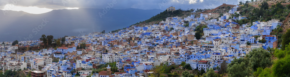 The blue city Chefchaouen / City view of the blue city Chefchaouen with dramatic sky, Morocco, Africa.