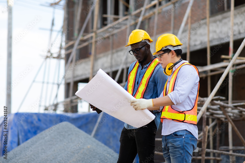 Professional Construction and Engineer team Working on workplace. Professional black architect and construction worker working look at blueprint plan on site. Professional Construction and Engineer team Working on workplace. Professional black architect and construction worker working look at blueprint plan on site.