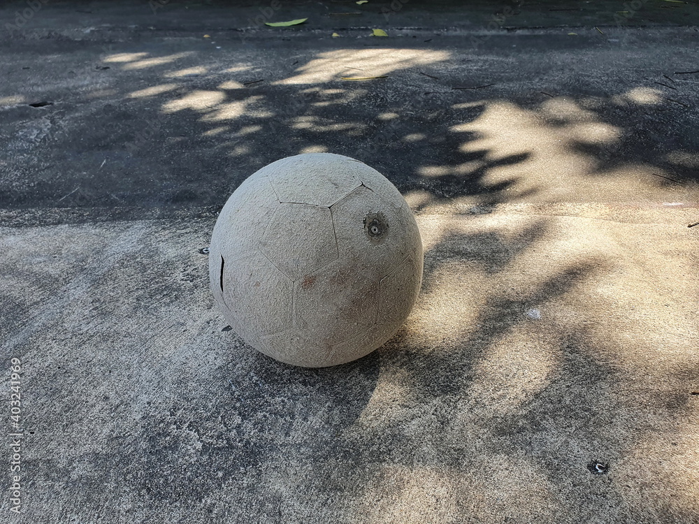 An old and worn out (torn) soccer ball was left on the cement floor of a village playground. Irresponsible children are out of order and often throw away toys.
An old and worn out (torn) soccer ball was left on the cement floor of a village playground. Irresponsible children are out of order and often throw away toys.
