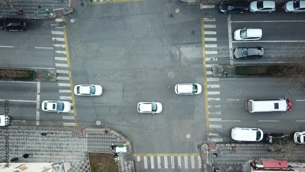 Aerial view of the city traffics at the center. Vehicles are moving on the road between buildings. Aerial view of the city traffics at the center. Vehicles are moving on the road between buildings.