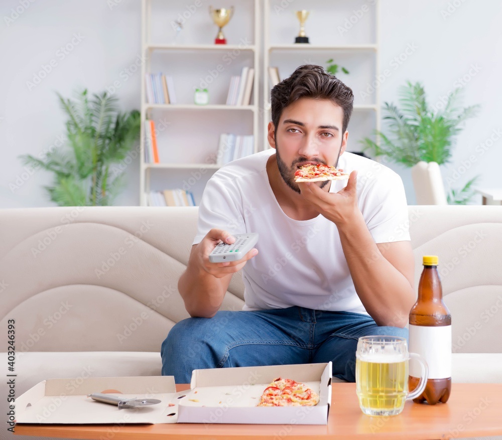 Man eating pizza having a takeaway at home relaxing resting Man eating pizza having a takeaway at home relaxing resting